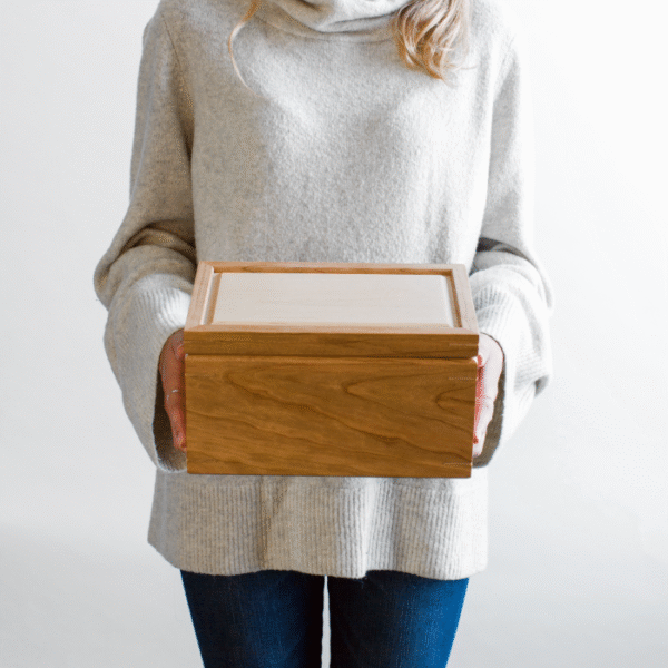 woman holding a handcrafted cherry box with a hard maple lid