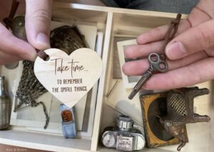 Heart tag engraved with “Take time… to remember the small things” next to antique key
