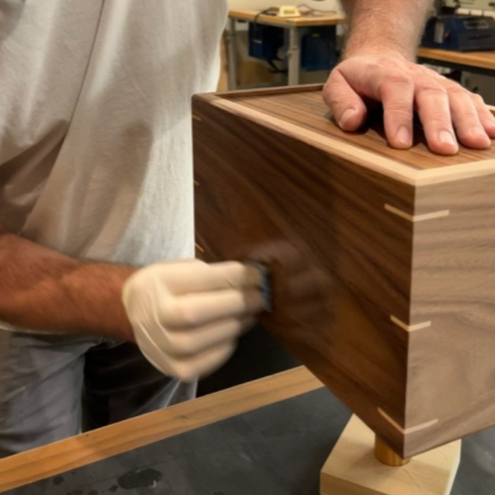 Applying finish to a walnut box by hand to bring out the natural grain