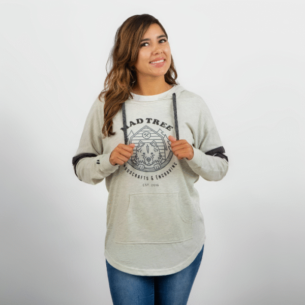 Woman smiling and looking to the side while wearing a light gray Mad Tree Woodcrafts & Engraving hoodie with a front pouch pocket and dark gray drawstrings.