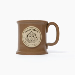 A brown ceramic Mad Tree Woodcrafts branded coffee mug set agains a white background.