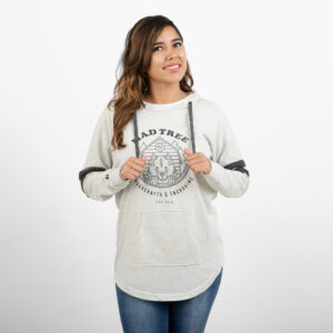 Woman smiling and looking to the side while wearing a light gray Mad Tree Woodcrafts & Engraving hoodie with a front pouch pocket and dark gray drawstrings.