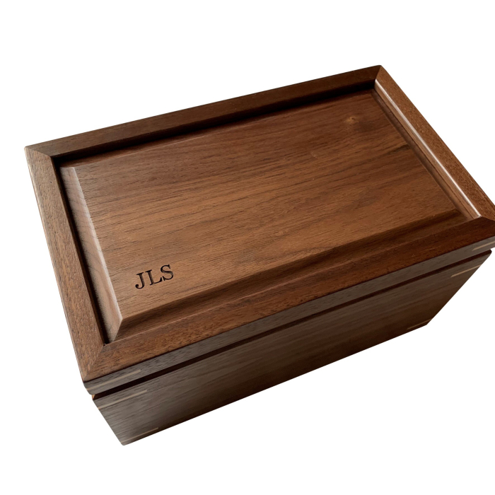 Walnut keepsake box with minimalist laser engraving of the initials “JLS” in the bottom corner of the lid; a classic monogram style by Mad Tree Woodcrafts.