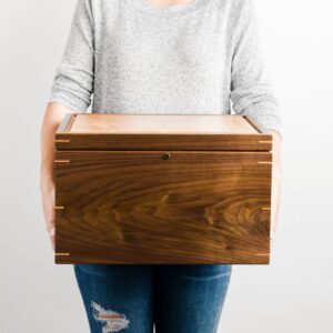 Personalized walnut and cherry keepsake box with lock held in hands for scale