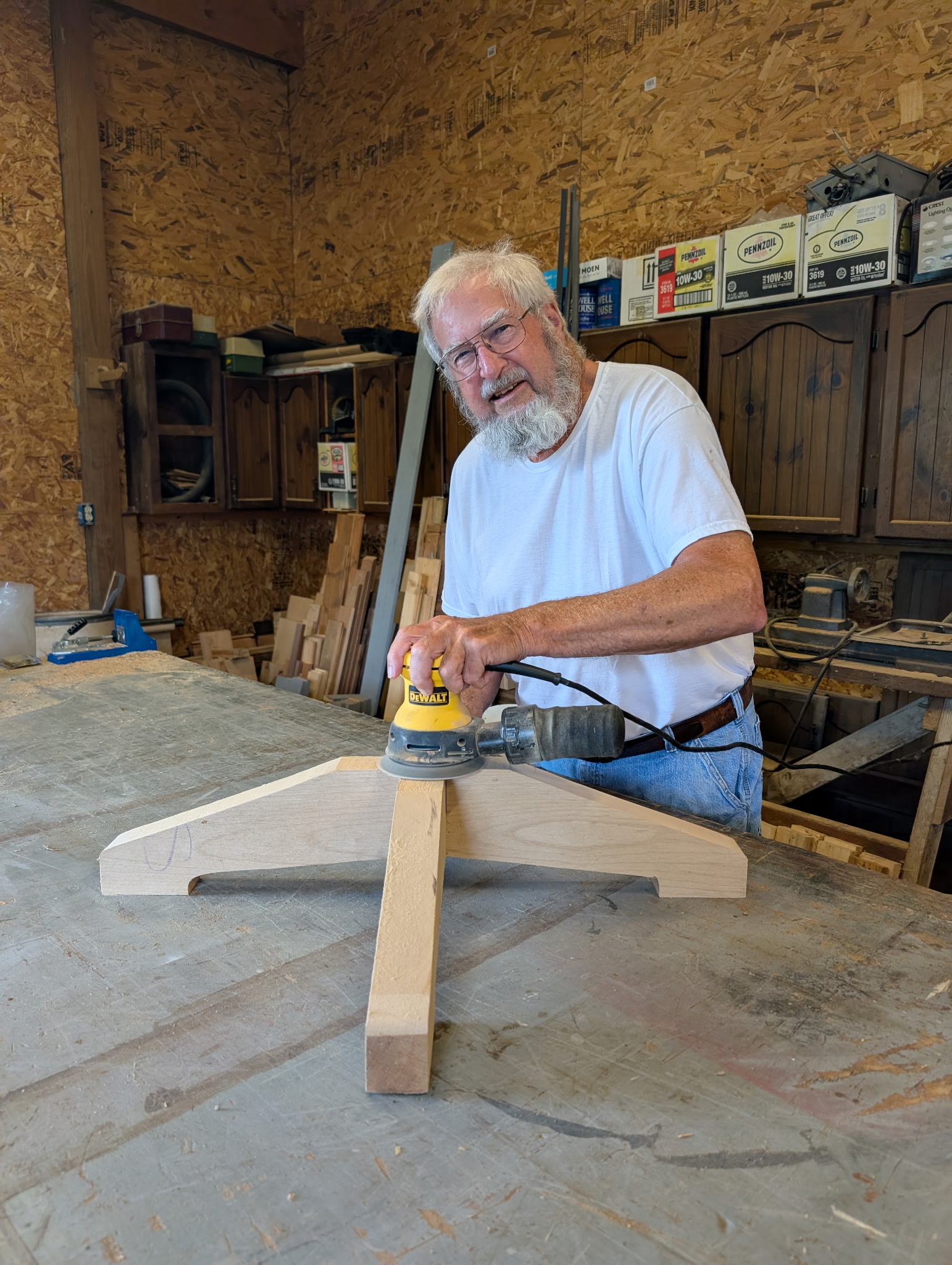 Larry Hall, father of Tyler Bishop Hall, sanding a woodworking project in his shop.