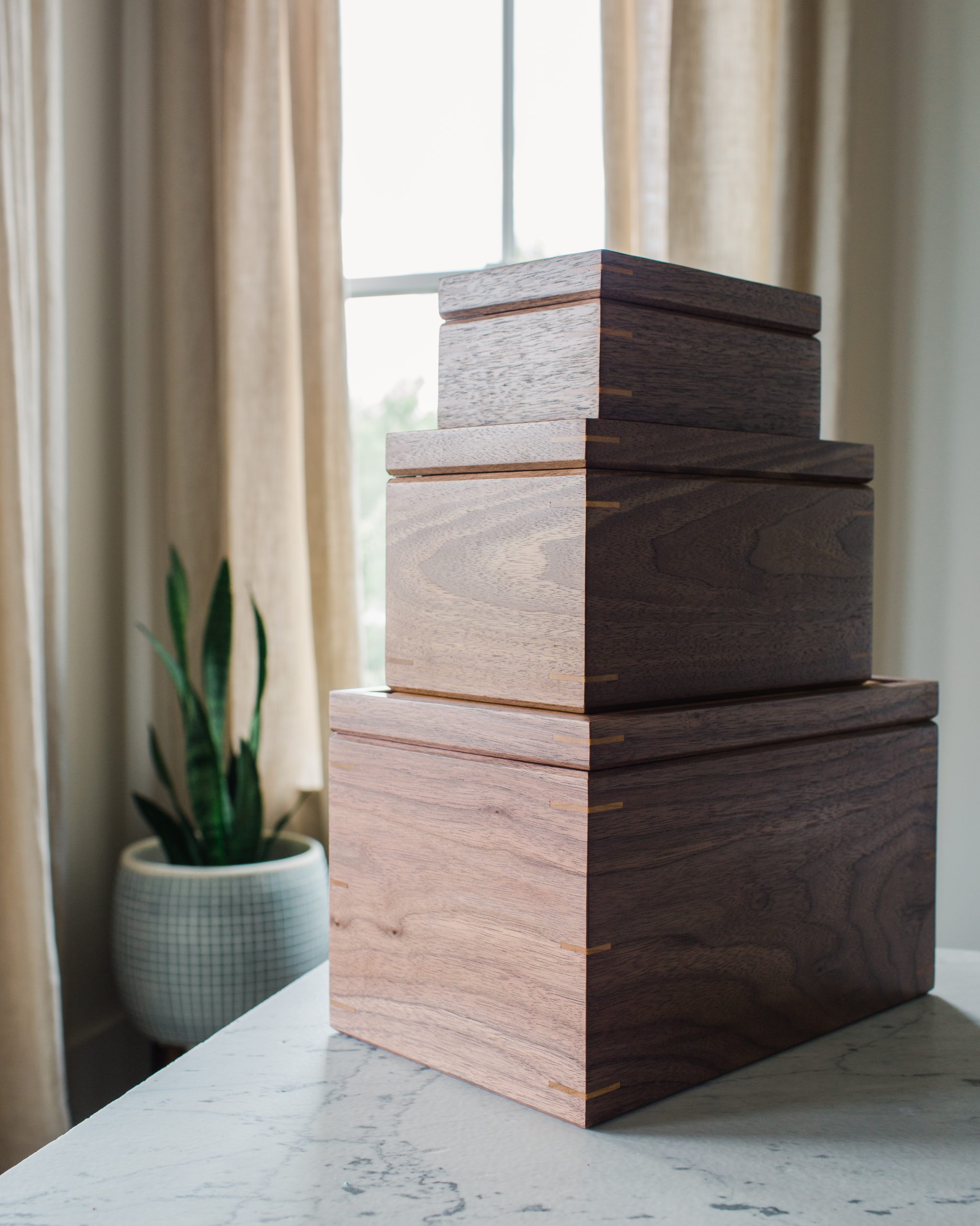 Stack of walnut keepsake boxes in multiple sizes, handcrafted by Mad Tree Woodcrafts.