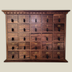 Handcrafted walnut advent calendar featuring 25 numbered drawers with antique-style pulls, made by Mad Tree Woodcrafts