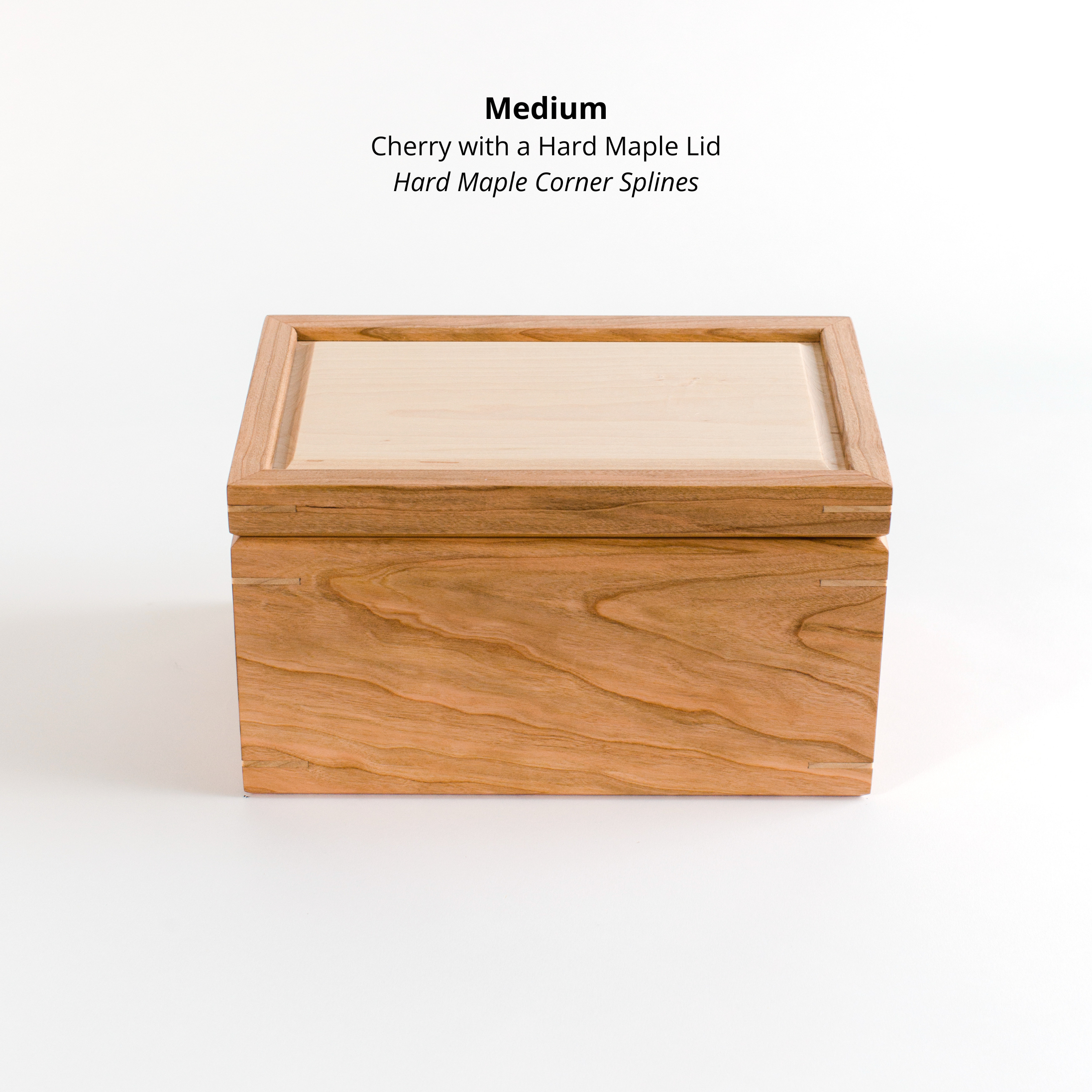 Handcrafted cherry keepsake box with hard maple lid inset and maple corner splines against a white background