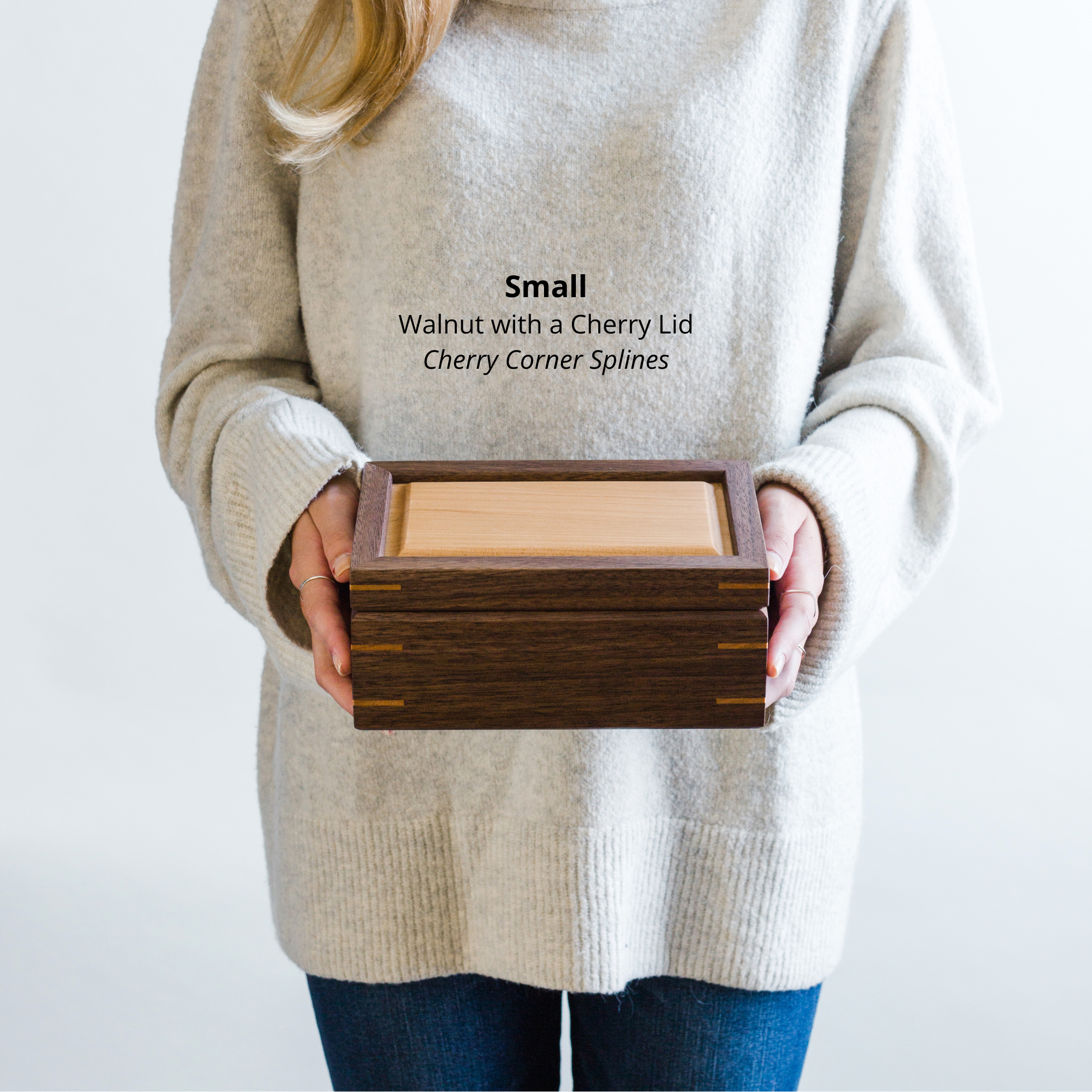 Woman holding a small walnut keepsake box with a cherry lid and cherry corner splines, to show size and scale